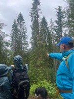 A participant’s photo of their family pointing to the tallest and largest tree they found downhill.